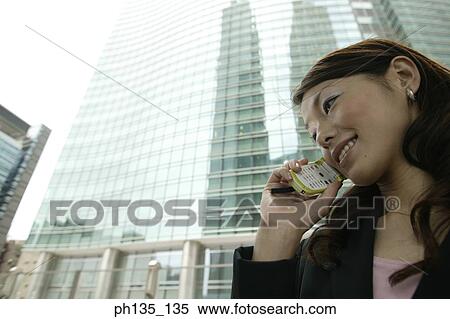 Young businesswoman talking on a mobile phone View Large Photo Image Stock Photography - Young businesswoman talking on a mobile phone. Fotosearch