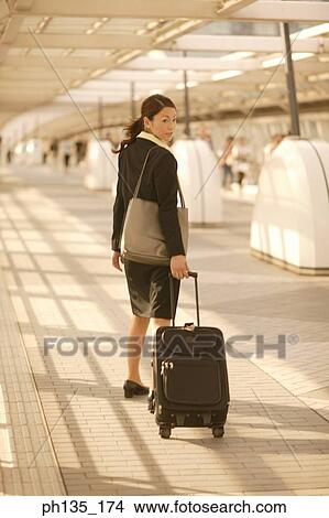 Young businesswoman walking with luggage View Large Photo Image Picture - Young businesswoman walking with luggage. Fotosearch