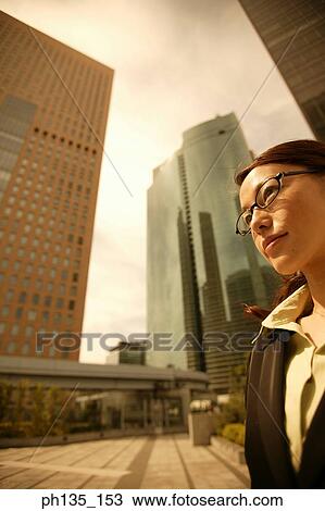 Stock Image - Young businesswoman wearing eye glasses looking ahead. Fotosearch