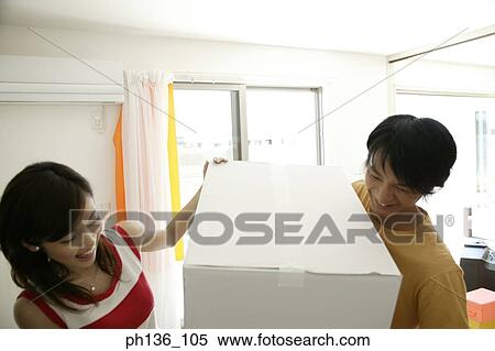 Stock Photography - Young couple carrying a box. Fotosearch