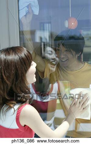 Stock Photograph - Young couple cleaning windows smiling. Fotosearch