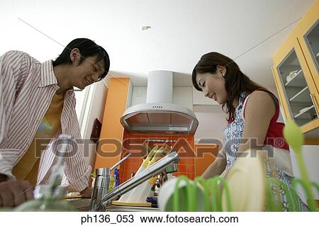Stock Image - Young couple cooking in the kitchen. Fotosearch