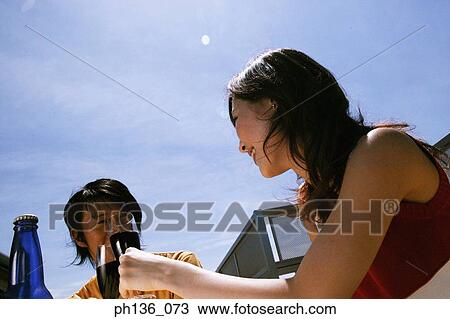 Stock Image - Young couple drinking red wine outdoors. Fotosearch