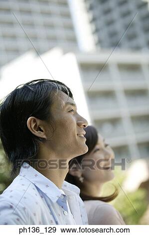 Young couple looking ahead smiling View Large Photo Image Stock Photo - Young couple looking ahead smiling. Fotosearch