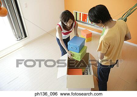 Stock Photograph - Young couple packing a box. Fotosearch