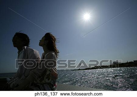 Stock Photo - Young couple sitting together outdoors. Fotosearch