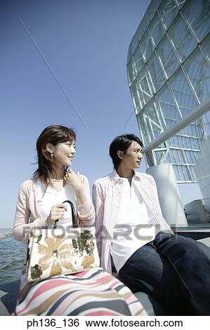Stock Photograph - Young couple sitting together outdoors. Fotosearch