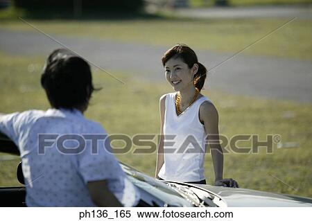 Young couple standing by a Car View Large Photo Image Stock Photography - Young couple standing by a Car. Fotosearch