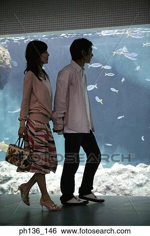 Stock Photograph - Young couple walking by an aquarium. Fotosearch