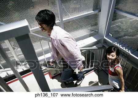 Stock Photo - Young couple walking up Stairs. Fotosearch