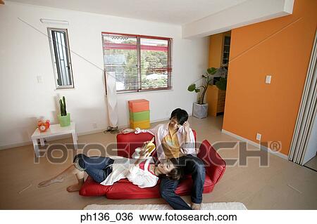 Young woman lying reading a book with a young man View Large Photo Image Stock Photograph - Young woman lying reading a book with a young man. Fotosearch