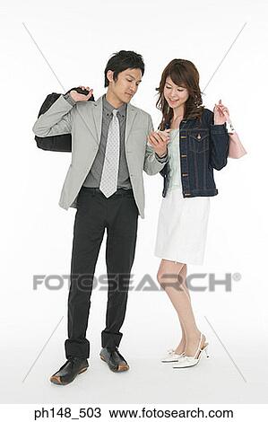 Businessman and a businesswoman listening to an MP3 player View Large Photo Image Stock Image - Businessman and a businesswoman listening to an MP3 player. Fotosearch