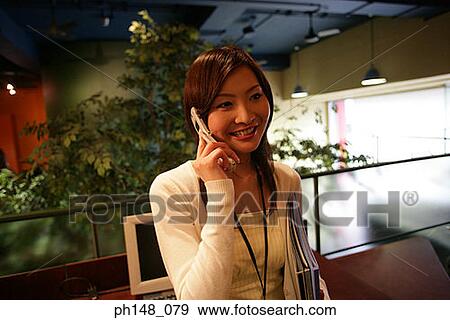 Businesswoman talking on a mobile phone and smiling View Large Photo Image Stock Photo - Businesswoman talking on a mobile phone and smiling. Fotosearch