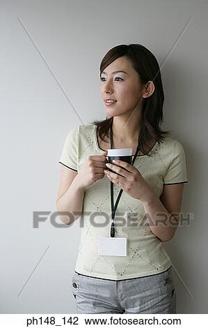 Stock Image - Close-up of a businesswoman holding a mug and smiling. Fotosearch