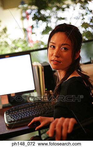 Close-up of a businesswoman sitting in front of a computer View Large Photo Image Stock Image - Close-up of a businesswoman sitting in front of a computer. Fotosearch