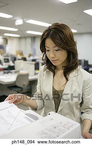 Picture - Close-up of a businesswoman using a photocopier. Fotosearch