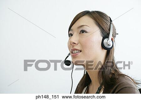Close-up of a businesswoman using a headset and smiling View Large Photo Image Stock Image - Close-up of a businesswoman using a headset and smiling. Fotosearch