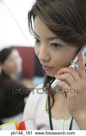 Stock Image - Close-up of a businesswoman using a mobile phone. Fotosearch