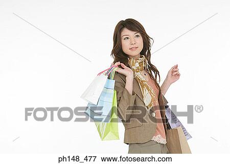Close-up of a young woman carrying shopping bags View Large Photo Image Stock Photo - Close-up of a young woman carrying shopping bags. Fotosearch