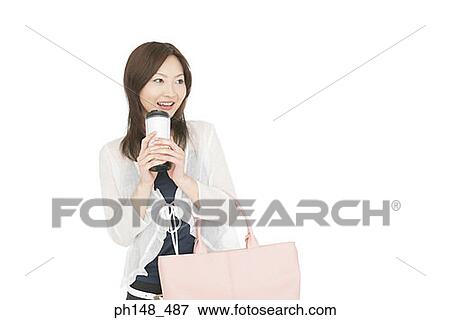 Close-up of a young woman holding a bottle and a purse View Large Photo Image Stock Photo - Close-up of a young woman holding a bottle and a purse. Fotosearch