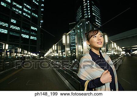 Stock Photo - Close-up of a young woman looking up and smiling. Fotosearch