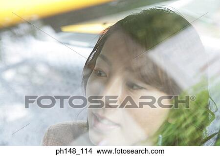 Close-up of a young woman smiling inside a car View Large Photo Image Picture - Close-up of a young woman smiling inside a car. Fotosearch