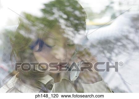 Close-up of a young woman talking on a mobile phone in a car View Large Photo Image Stock Image - Close-up of a young woman talking on a mobile phone in a car. Fotosearch