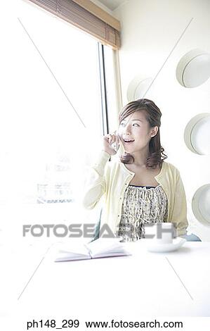 Stock Photo - Close-up of a young woman talking on a mobile phone. Fotosearch
