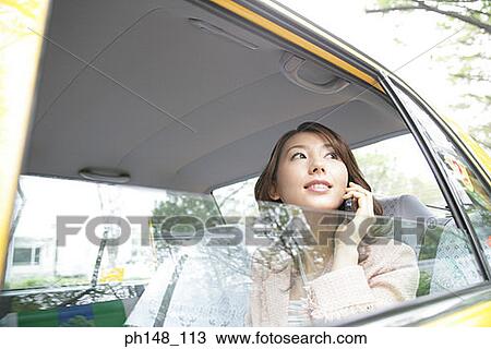 Close-up of a young woman using a mobile phone in a car View Large Photo Image Stock Image - Close-up of a young woman using a mobile phone in a car. Fotosearch