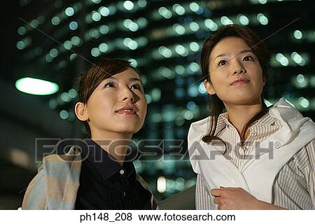 Close-up of two young women looking up View Large Photo Image Stock Photo - Close-up of two young women looking up. Fotosearch