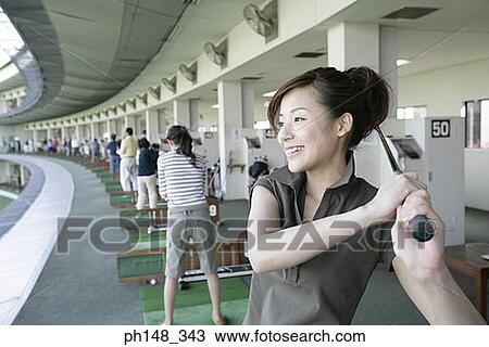 Stock Image - Close-up of two young women playing golf. Fotosearch