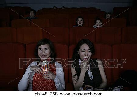Close-up of two young women watching a movie in a movie theater View Large Photo Image Stock Photo - Close-up of two young women watching a movie in a movie theater. Fotosearch