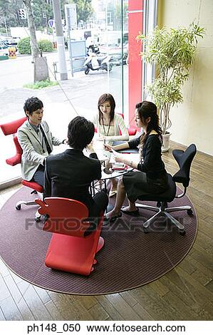 Stock Image - High angle view of two businessmen and two businesswomen in a meeting. Fotosearch