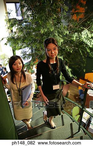 High angle view of two businesswomen walking up a spiral staircase View Large Photo Image Stock Image - High angle view of two businesswomen walking up a spiral staircase. Fotosearch