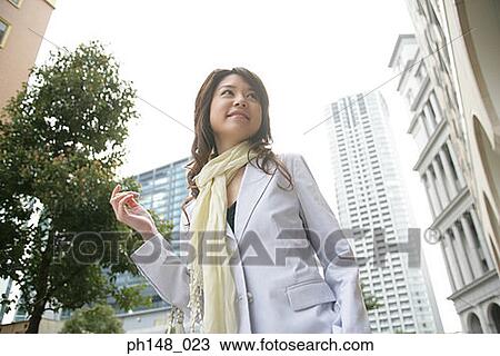 Stock Image - Low angle view of a businesswoman smiling. Fotosearch
