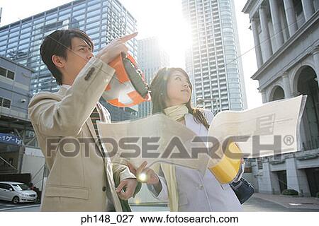 Low angle view of a male and a female architect holding blueprints and looking up View Large Photo Image Stock Photo - Low angle view of a male and a female architect holding blueprints and looking up. Fotosearch