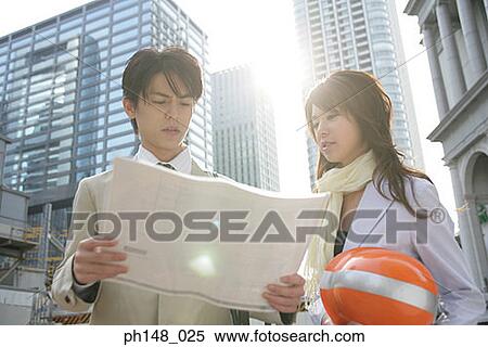 Low angle view of a male and a female architect looking at a blueprint View Large Photo Image Stock Photography - Low angle view of a male and a female architect looking at a blueprint. Fotosearch
