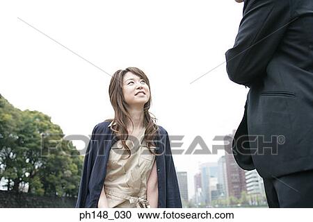 Low angle view of a young woman smiling View Large Photo Image Stock Image - Low angle view of a young woman smiling. Fotosearch