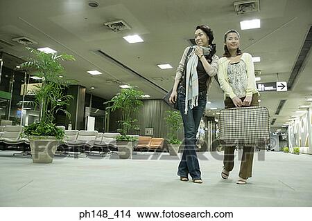 Low angle view of two young women at a subway station with luggage View Large Photo Image Picture - Low angle view of two young women at a subway station with luggage. Fotosearch