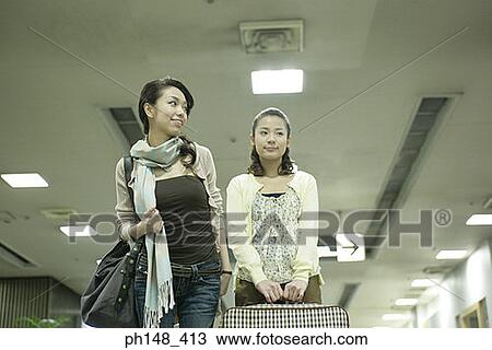 Low angle view of two young women at a subway station with luggage View Large Photo Image Stock Image - Low angle view of two young women at a subway station with luggage. Fotosearch