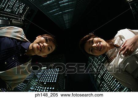 Low angle view of two young women smiling View Large Photo Image Stock Photography - Low angle view of two young women smiling. Fotosearch