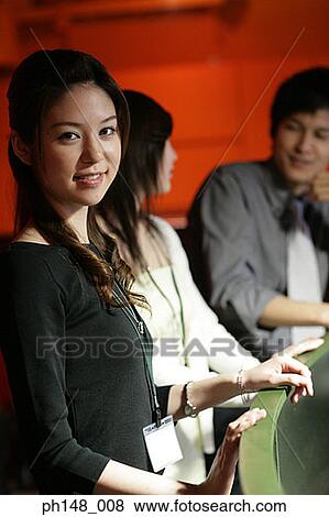 Portrait of a businessman smiling with her two colleagues in the background View Large Photo Image Stock Photo - Portrait of a businessman smiling with her two colleagues in the background. Fotosearch