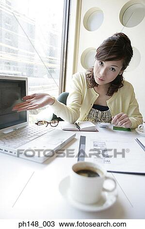 Portrait of a businesswoman gesturing towards a laptop View Large Photo Image Stock Image - Portrait of a businesswoman gesturing towards a laptop. Fotosearch