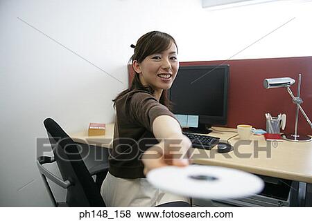 Portrait of a businesswoman holding a CD and looking cheerful View Large Photo Image Stock Photo - Portrait of a businesswoman holding a CD and looking cheerful. Fotosearch