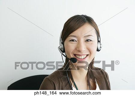 Picture - Portrait of a businesswoman wearing a headset and smiling. Fotosearch