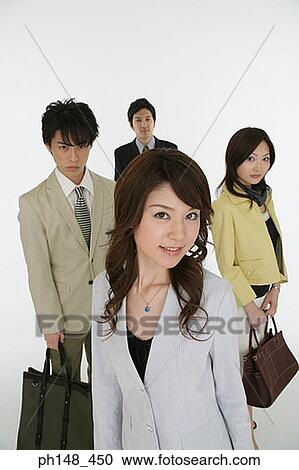 Stock Image - Portrait of a businesswoman with colleagues in the background. Fotosearch