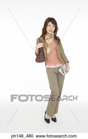 Portrait of a young woman carrying a purse and holding a newspaper View Large Photo Image Stock Image - Portrait of a young woman carrying a purse and holding a newspaper. Fotosearch
