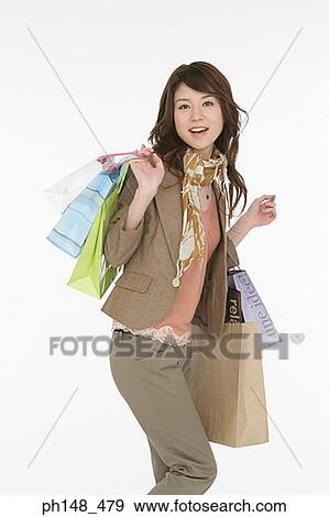 Stock Photo - Portrait of a young woman carrying shopping bags. Fotosearch