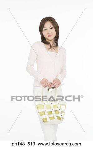 Stock Photo - Portrait of a young woman holding a purse. Fotosearch