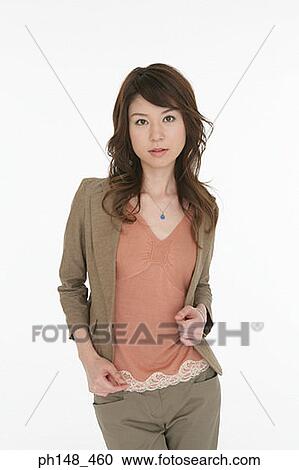 Stock Image - Portrait of a young woman holding her coat. Fotosearch
